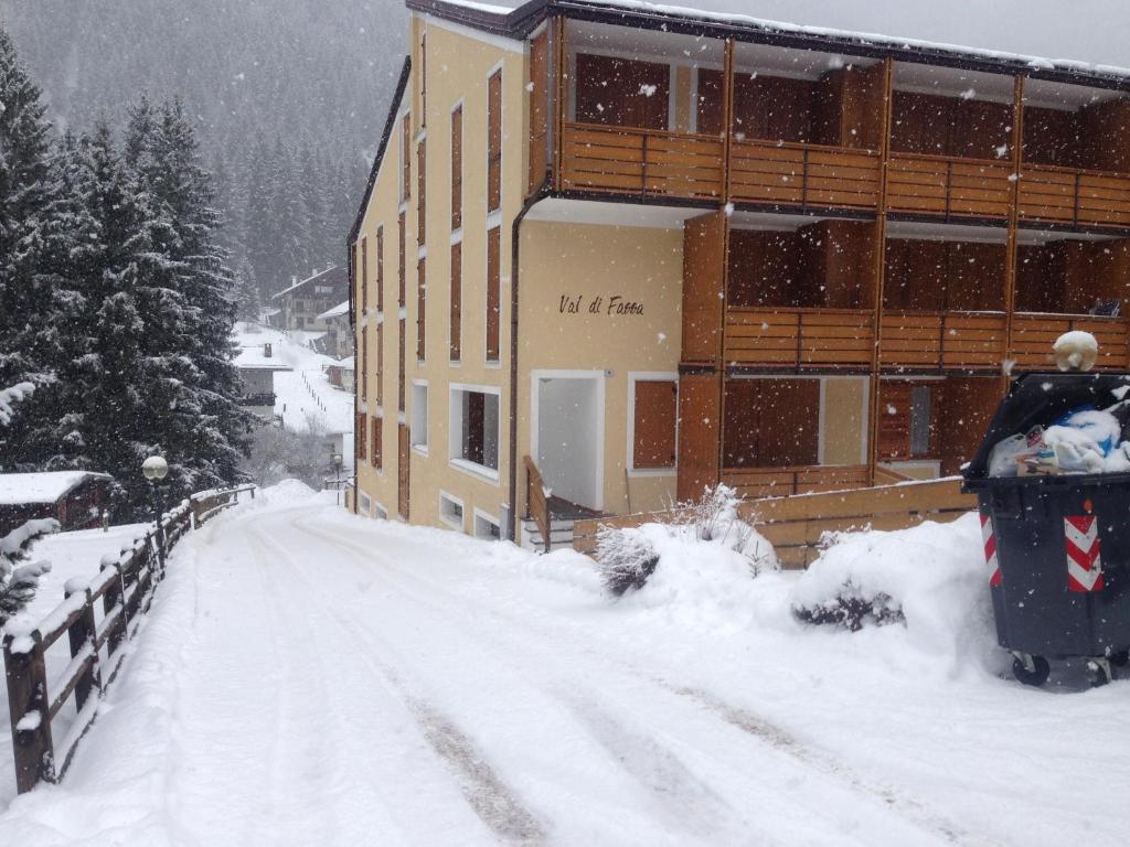 a snow covered road in front of a building at Canazei Vacanze Dolomiti in Alba di Canazei