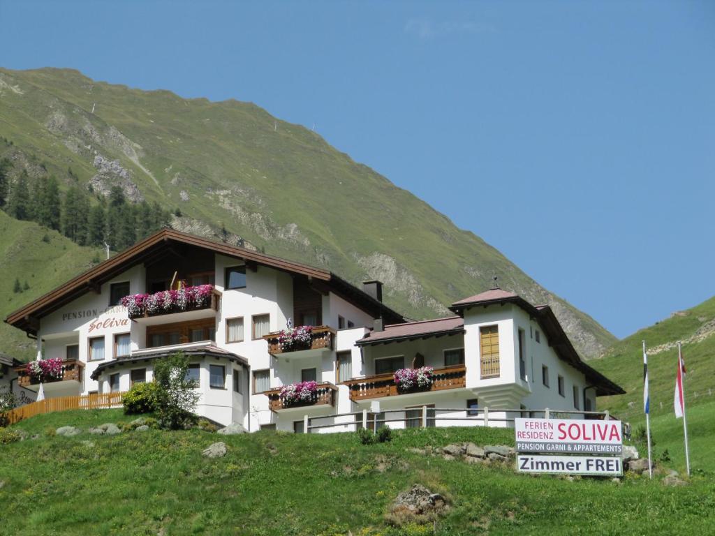 a building on a hill with a sign in front of it at Ferienresidenz Soliva in Samnaun