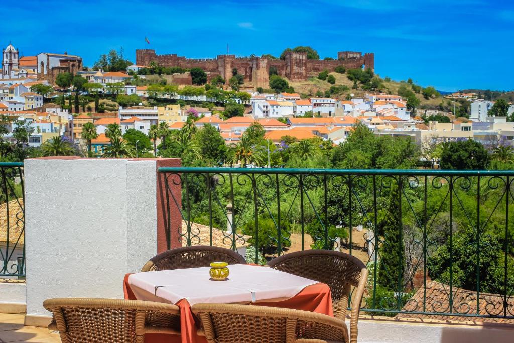a table on a balcony with a view of a city at Hotel Colina Dos Mouros in Silves