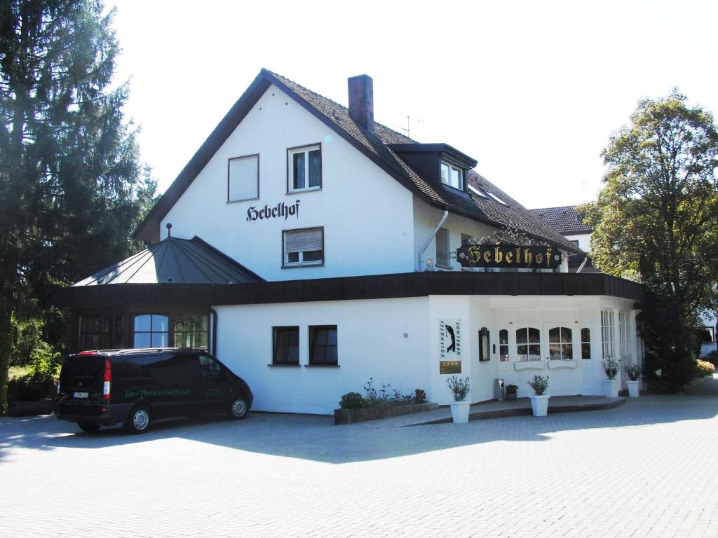 une camionnette garée devant un bâtiment blanc dans l'établissement Golfhotel Hebelhof, à Bad Bellingen
