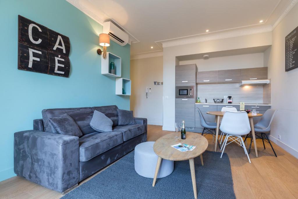 a living room with a couch and a table at Florella Jean Jaures Apartment in Cannes