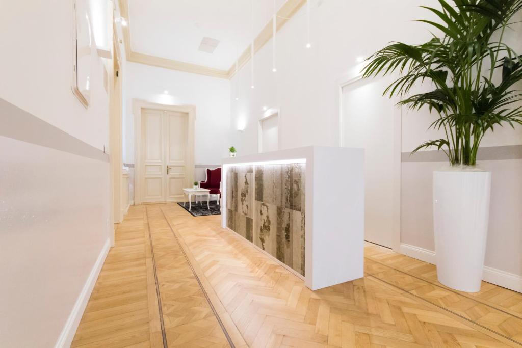 トリエステにあるResidenza Degli Artistiの鉢植えの白い部屋のある廊下