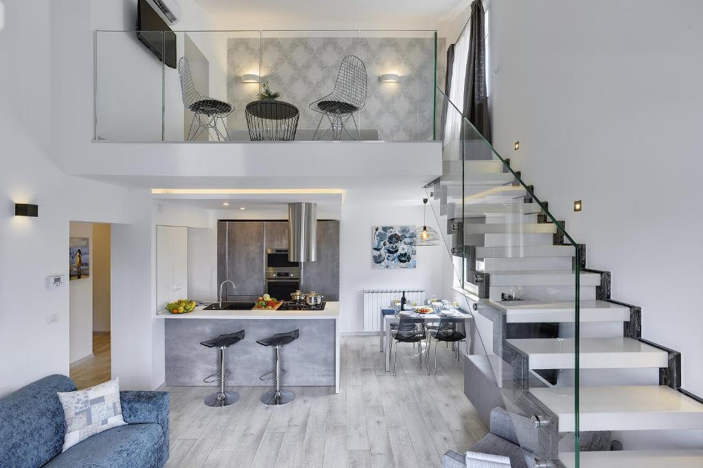 a living room and kitchen with a staircase in a house at Gallery Apartment in Pula