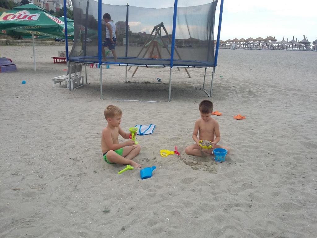 コンスタンツァにあるApartament 2 camere Constantaの砂浜で遊ぶ二人の若者