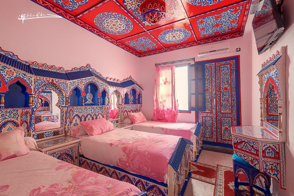 um quarto com 2 camas e um tecto colorido em Hotel Madrid em Chefchaouen