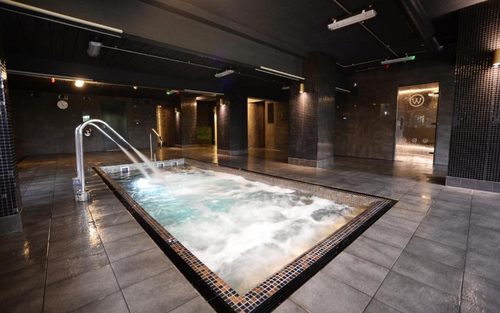 a jacuzzi tub in a large room with clouds at The Waterside Hotel and Leisure Club in Manchester