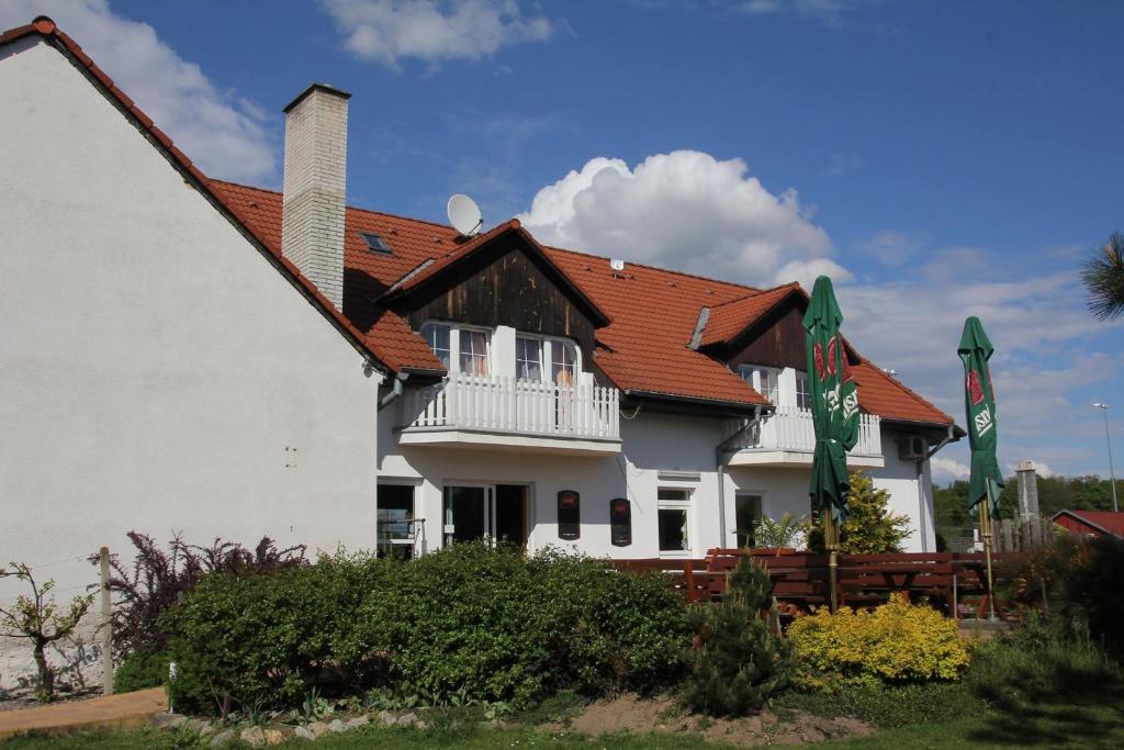 une maison blanche avec un toit rouge dans l'établissement Penzion Šalamoun, à Jevišovice