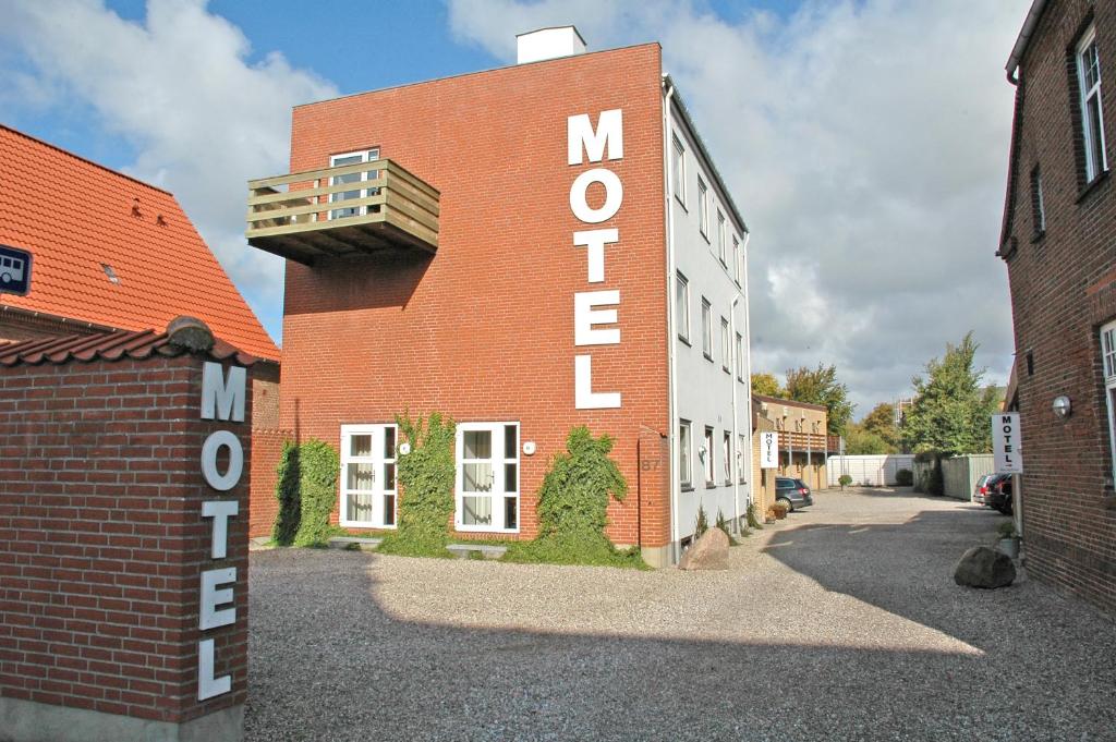 a brick building with a sign that reads my house at Motel Apartments in Tønder