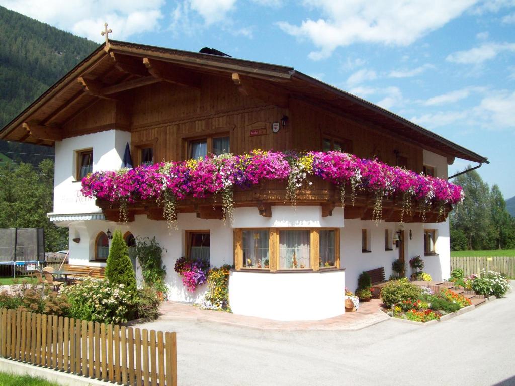 une maison avec des fleurs sur son côté dans l'établissement Haus Reiterer, à Neustift im Stubaital