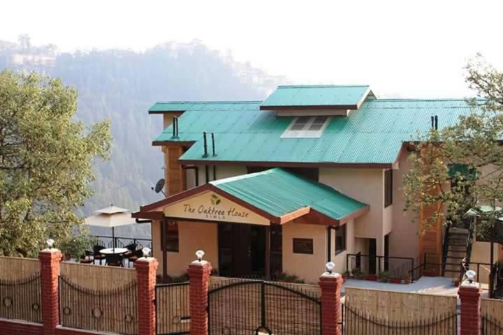 a house with a fence in front of it at The Oaktree House in Shimla