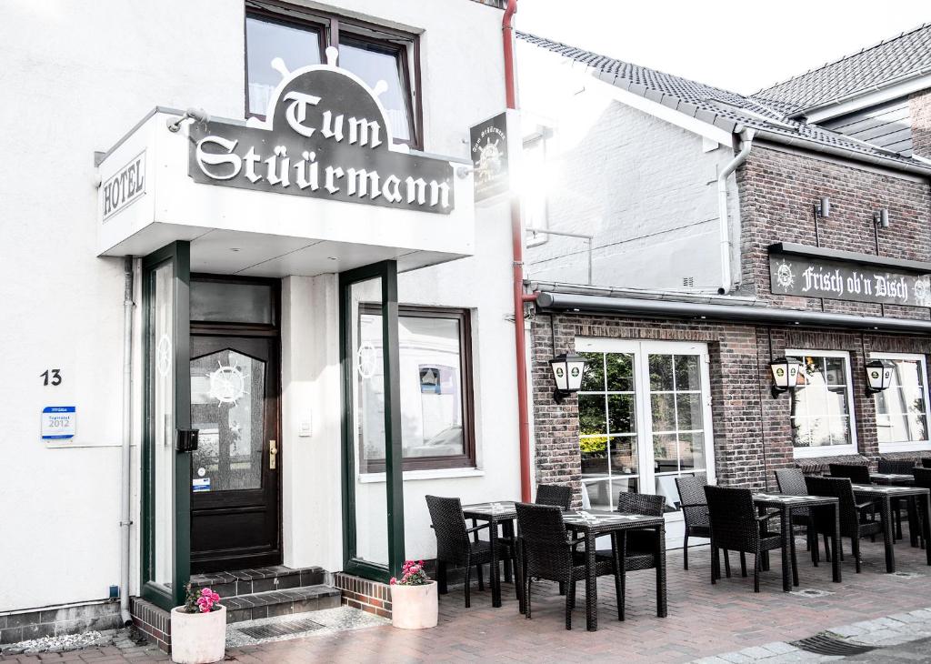 Hotel Tum Stüürmann في بوسوم: مطعم بطاولات وكراسي خارجه