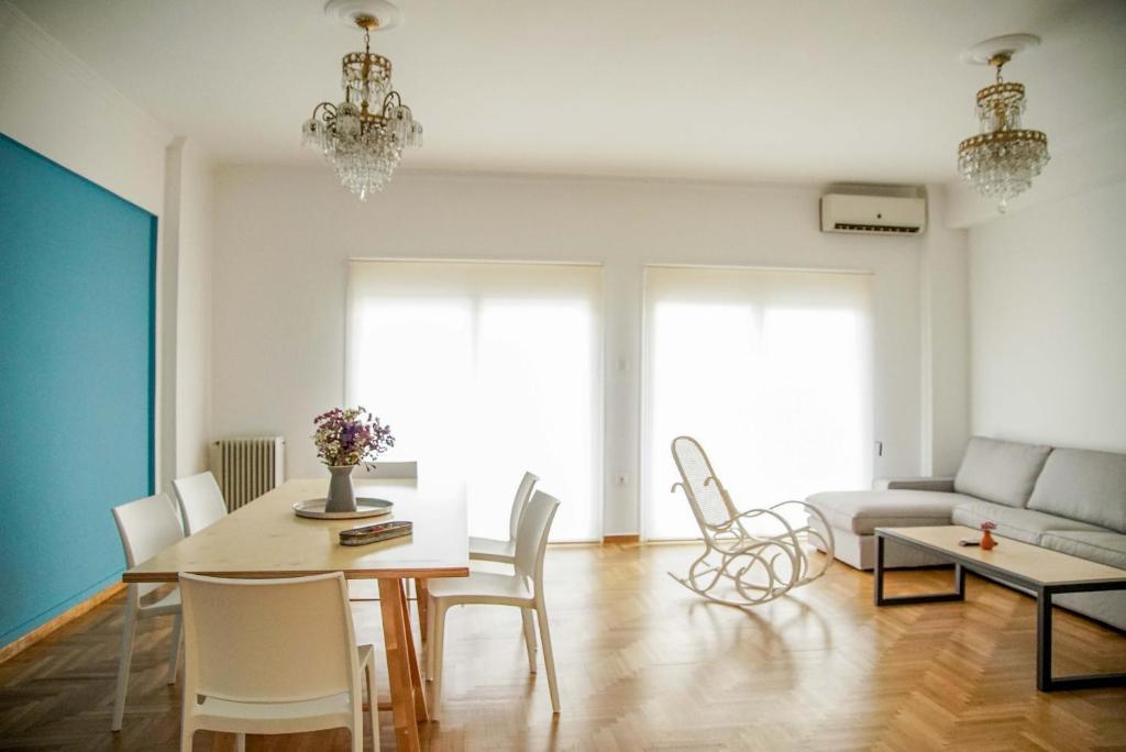 a living room with a table and chairs and a couch at Athenian Blue - Family Apt 5' Minutes from Acropolis Museum in Athens