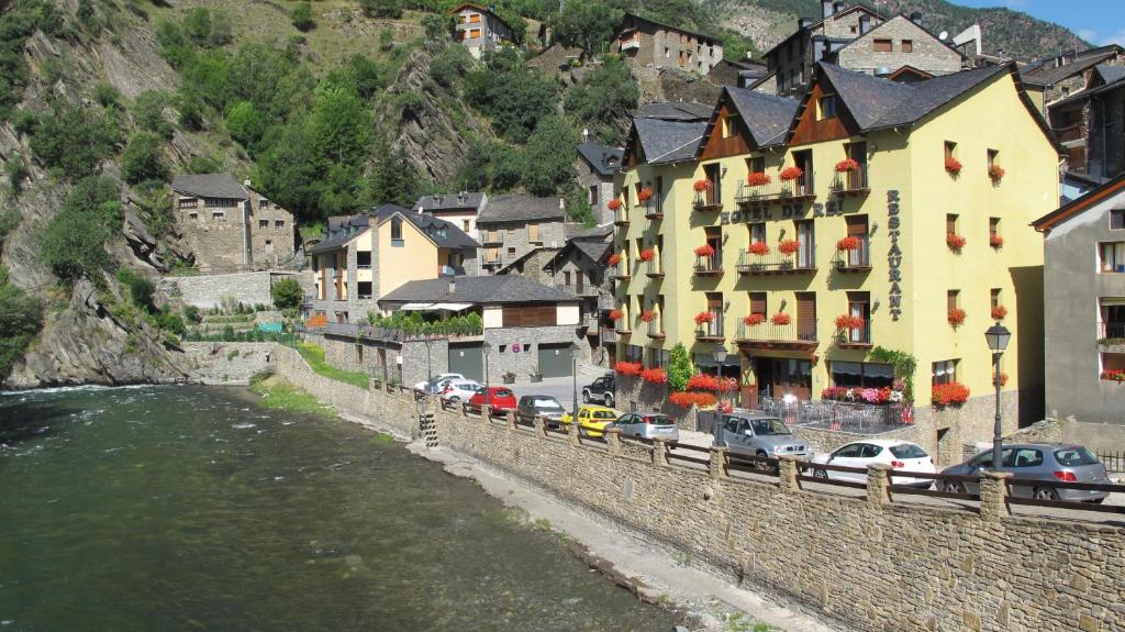 een groep gebouwen aan de oever van een rivier bij Hotel De Rei in Llavorsí