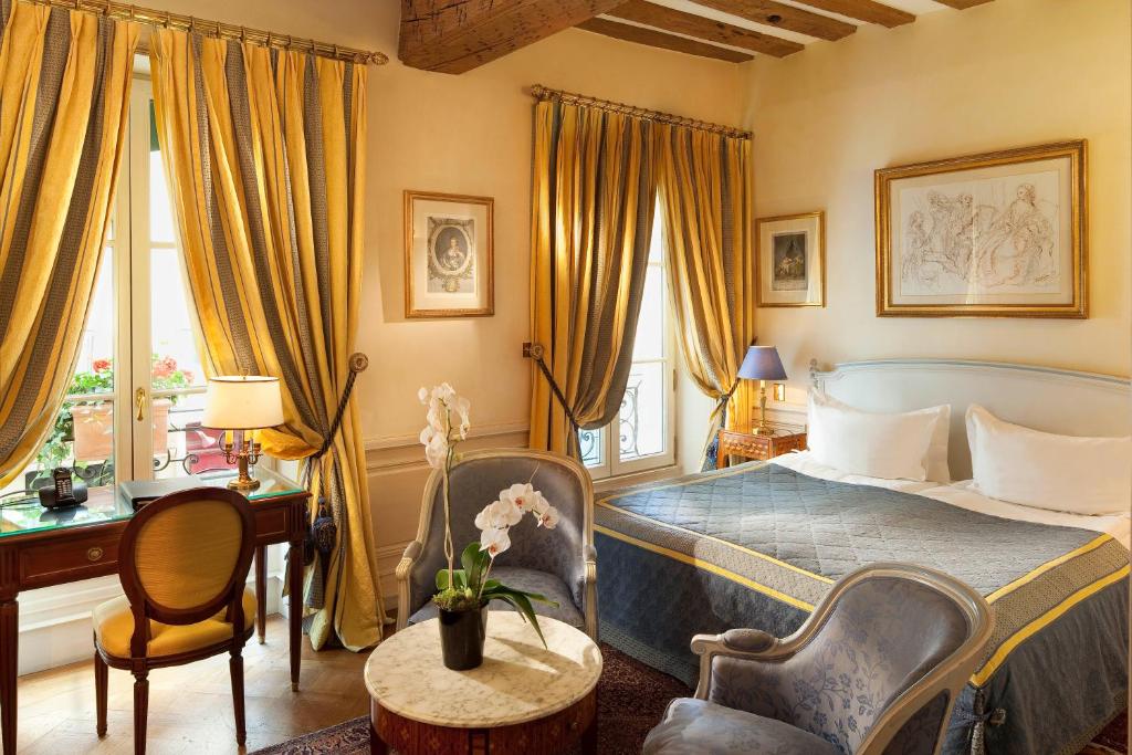 パリにあるホテル ルクセンブルク パルクのベッドルーム1室(ベッド1台、テーブル、椅子付)