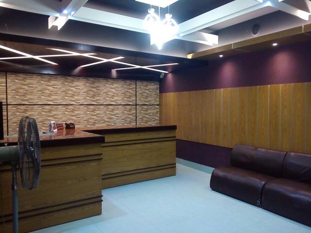 a waiting room with a counter and a leather couch at Hotel Marine Plaza in Cox's Bazar