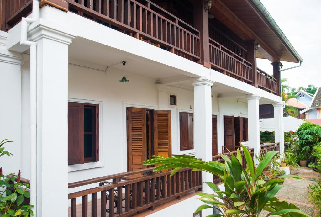 a house with a balcony and wooden doors at Cold River in Luang Prabang