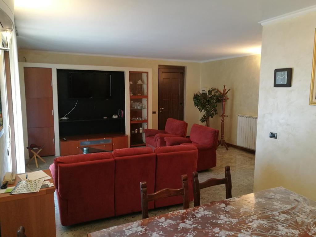 een woonkamer met twee rode banken en een flatscreen-tv bij Pellico Apartment in Brusaporto