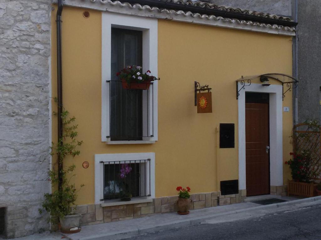 Una casa amarilla con una ventana con flores. en Casa Vacanze Il Sole e la Luna en Guardiagrele