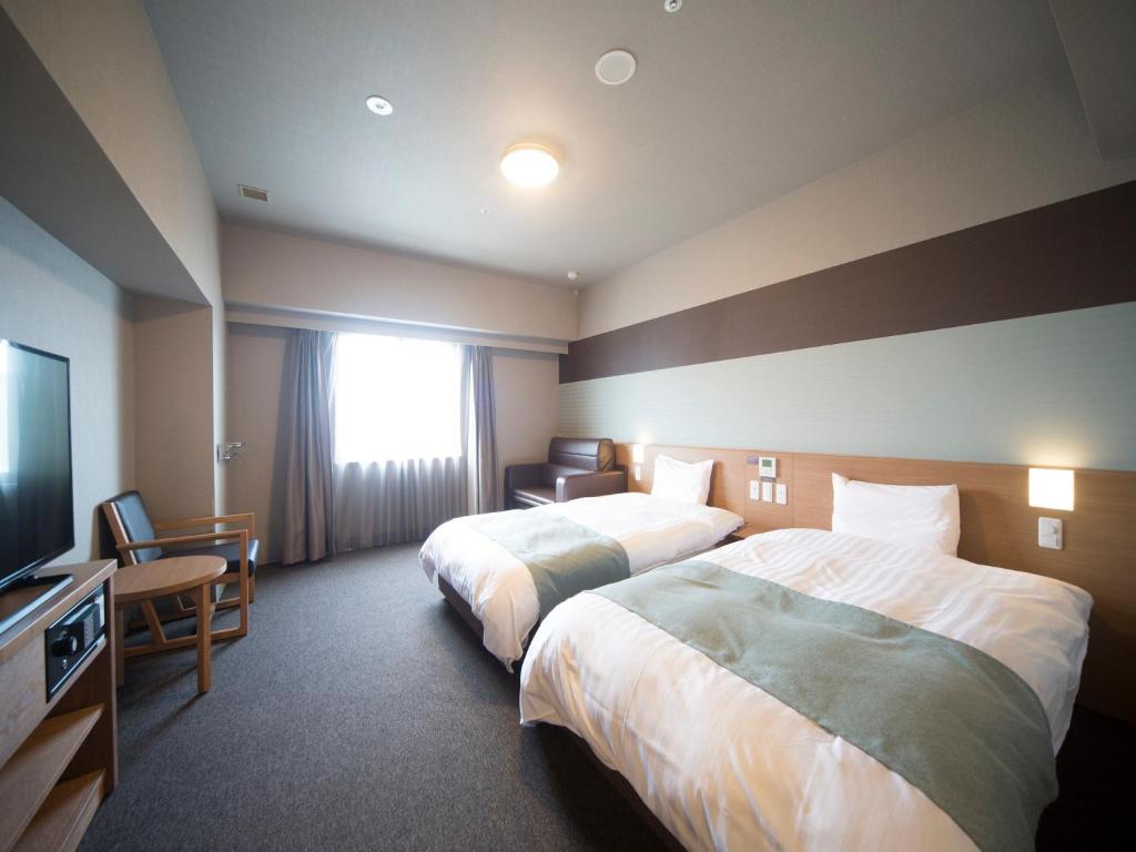 Postel nebo postele na pokoji v ubytování Dormy Inn Izumo