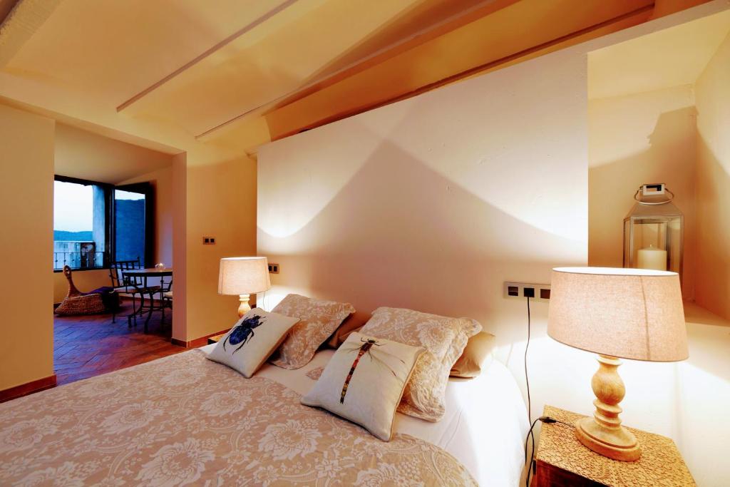 a bedroom with a large bed with two lamps at Dalt Vila in Eslida