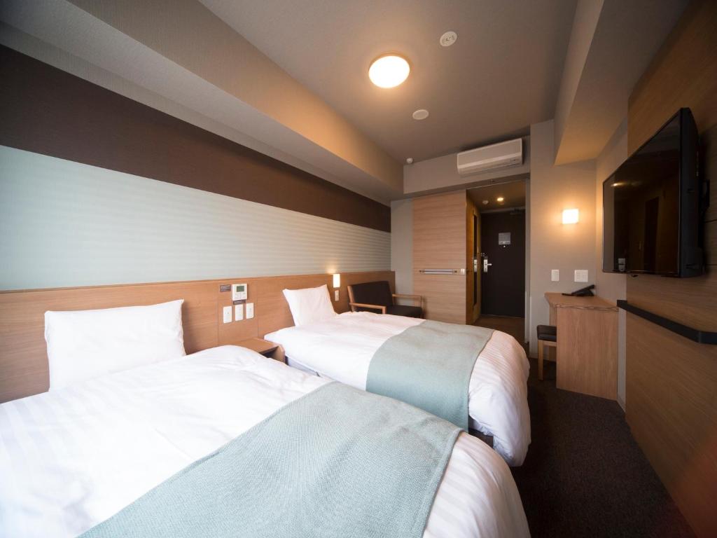 Postel nebo postele na pokoji v ubytování Dormy Inn Izumo