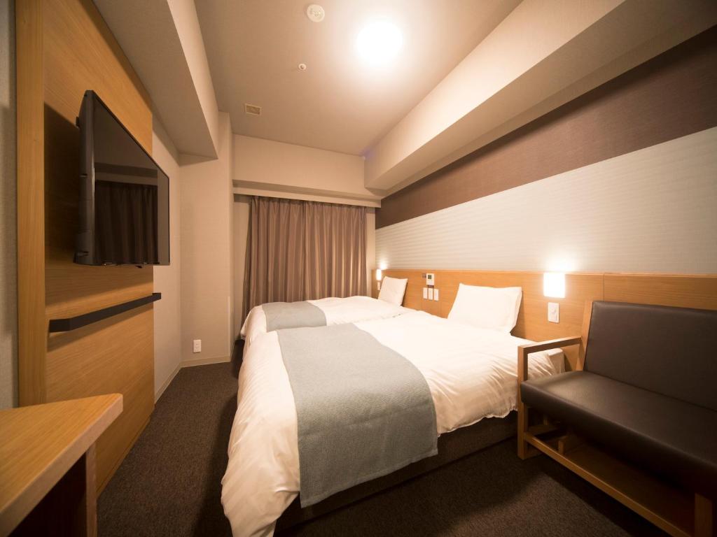 Postel nebo postele na pokoji v ubytování Dormy Inn Izumo
