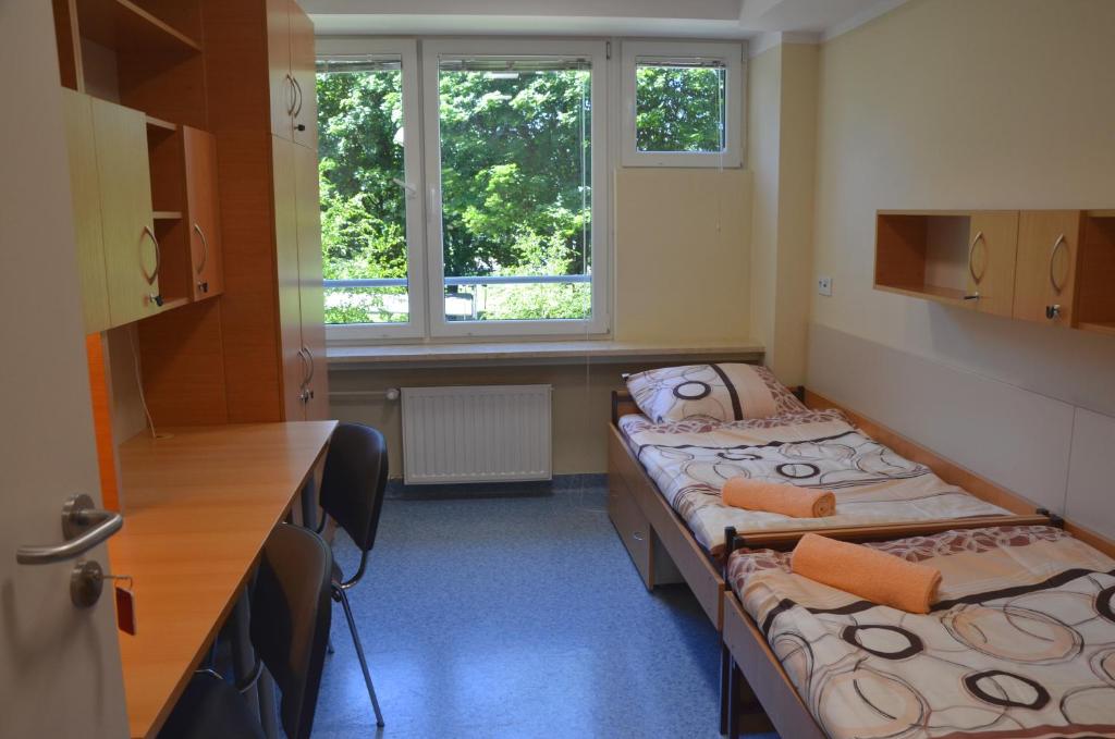 a room with two beds and a window at Babilon in Krakow