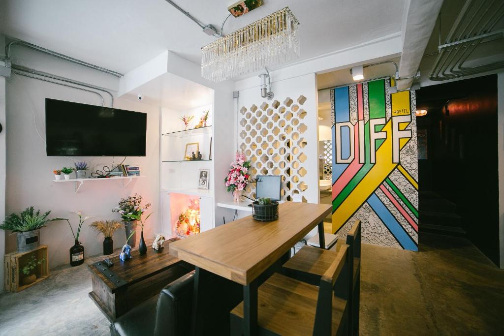 een eetkamer met een tafel en een tv bij Diff Hostel in Bangkok