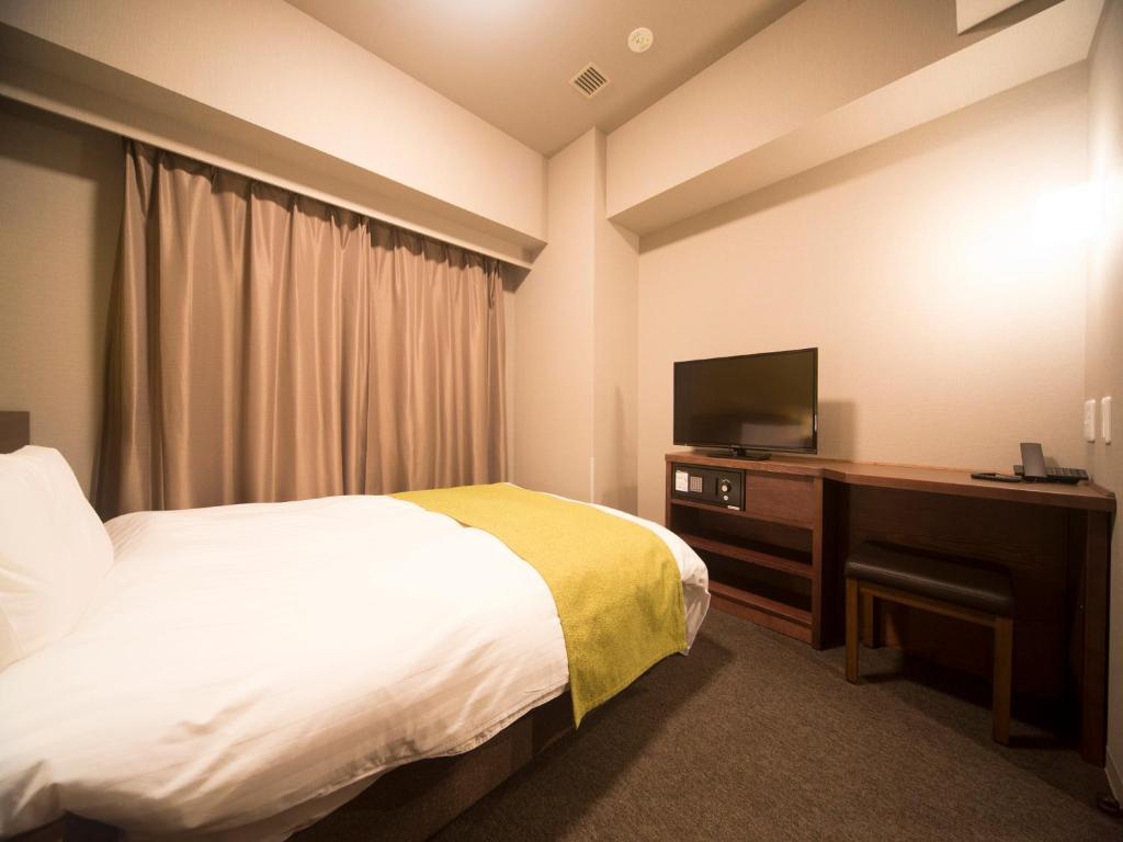 Postel nebo postele na pokoji v ubytování Dormy Inn Izumo