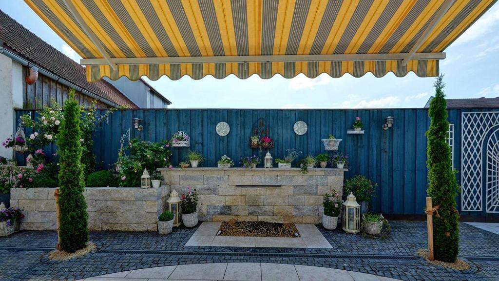 a patio with a fountain and a blue fence at Pension Mair in Stetten