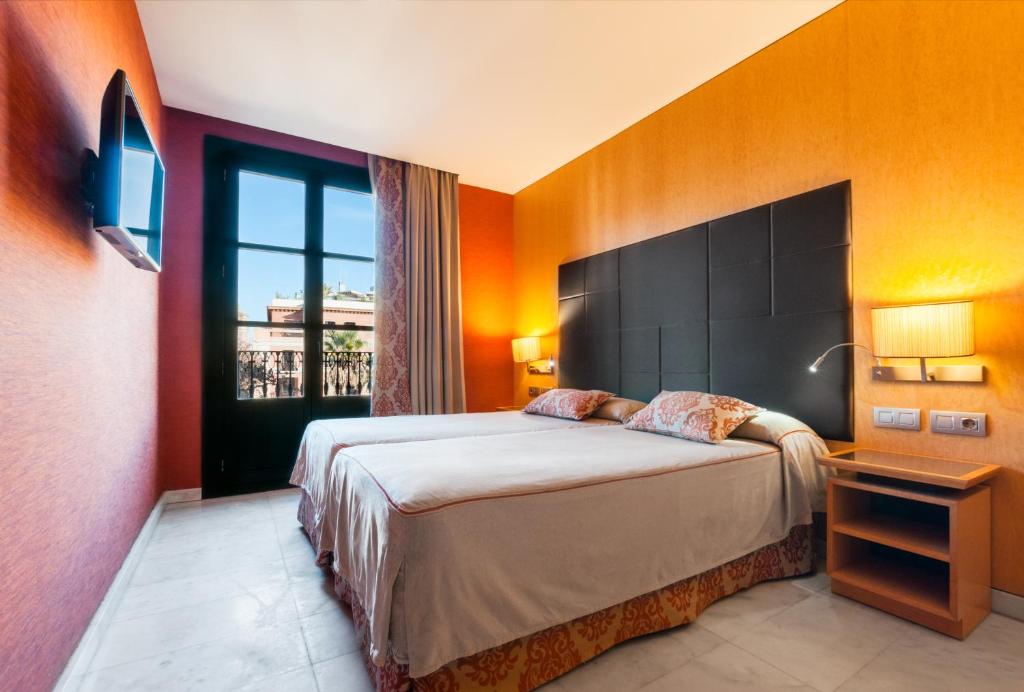 sypialnia z łóżkiem i dużym oknem w obiekcie Hotel Medinaceli w Barcelonie
