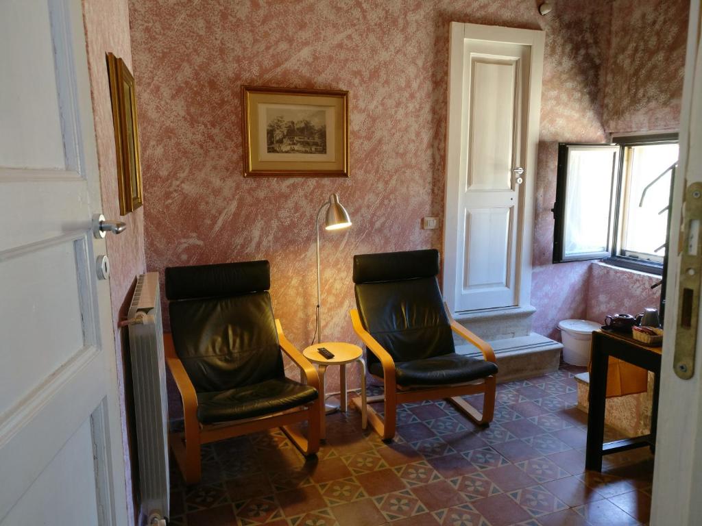 Pokój z 2 krzesłami, stołem i lampką w obiekcie B&B Porta della Terra w mieście Militello in Val di Catania
