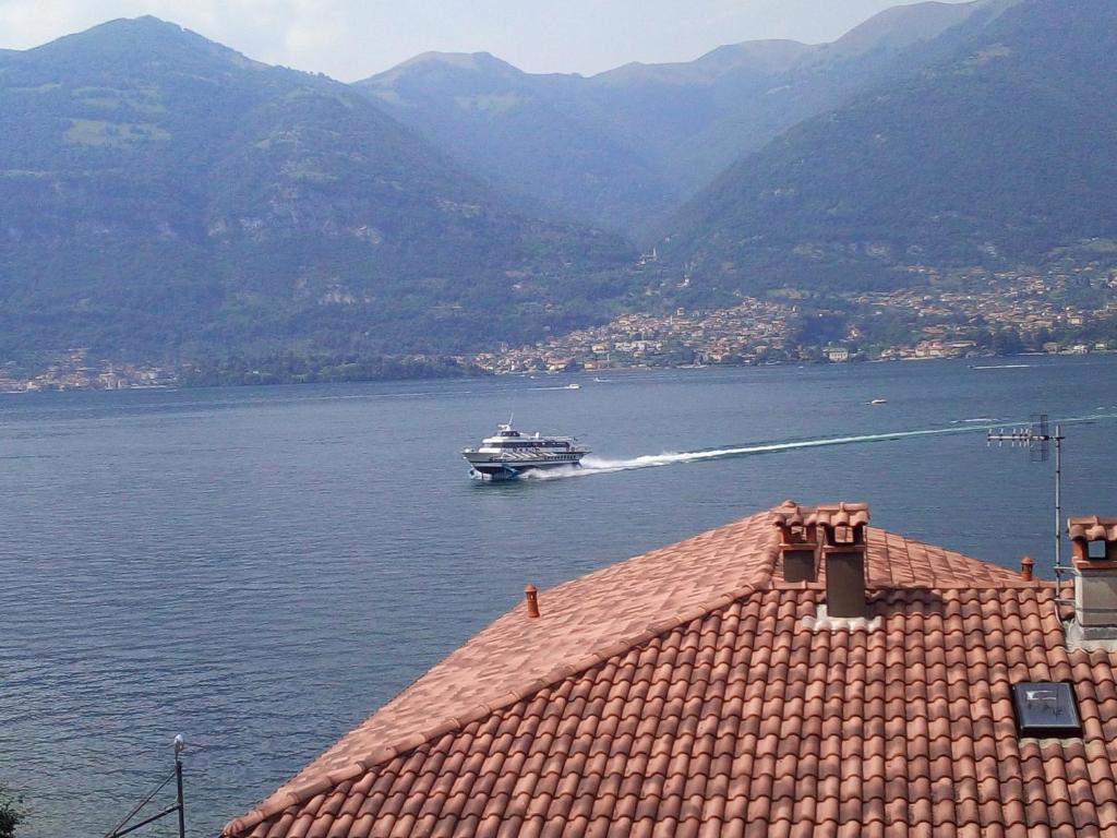 een boot op het water met bergen op de achtergrond bij Casa Valli in Lezzeno