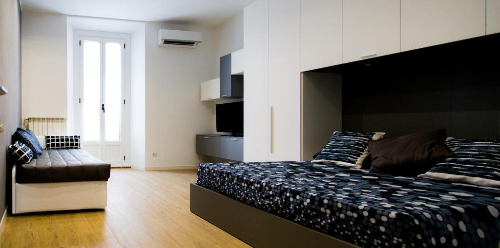- une chambre avec un grand lit et un canapé dans l'établissement P&D Apartments Navigli, à Milan