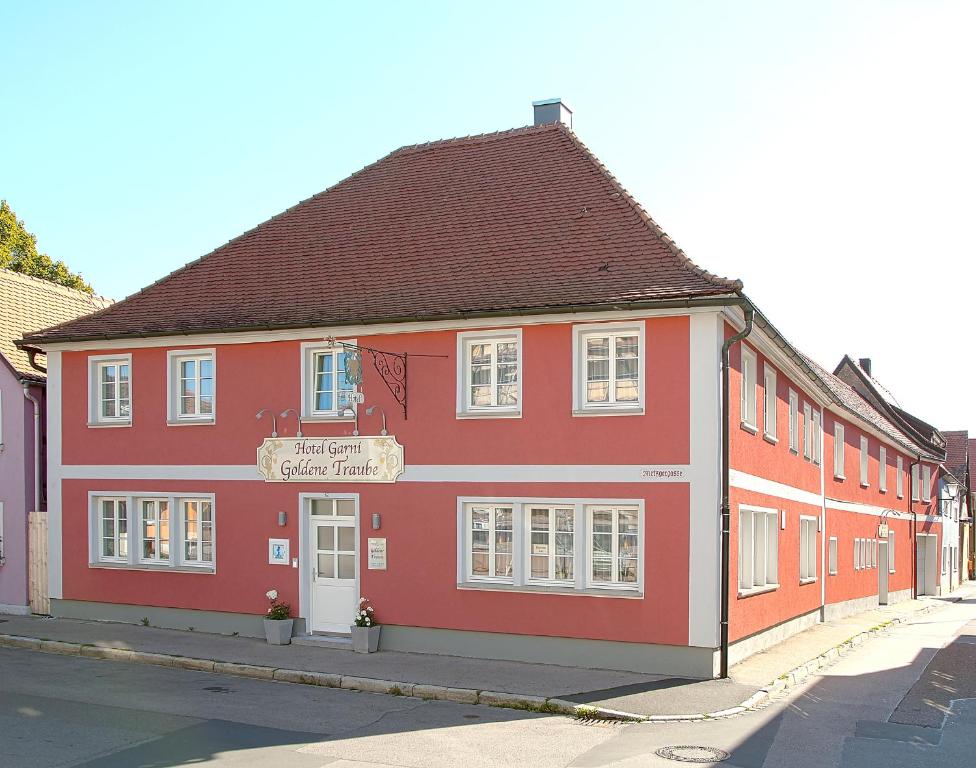 a red building on the side of a street at Hotel Garni Goldene Traube in Bad Windsheim