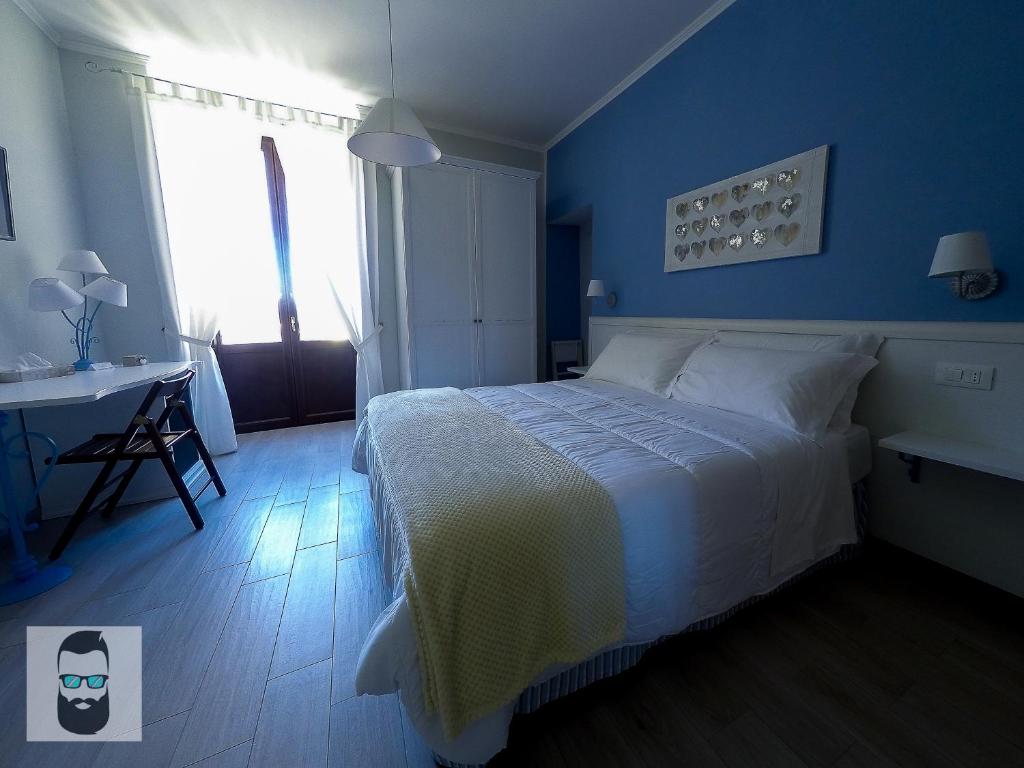 1 dormitorio con cama, escritorio y ventana en ReginElena B&B, en Maratea