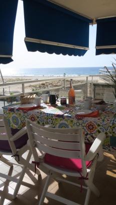 a table and chair on a balcony with a view of the ocean at A3A Baixa Mar in Torredembarra