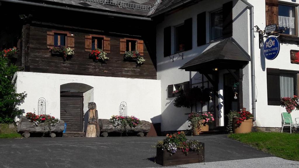 a building with a statue and flowers in front of it at Alpengasthof Hoiswirt in Modriach