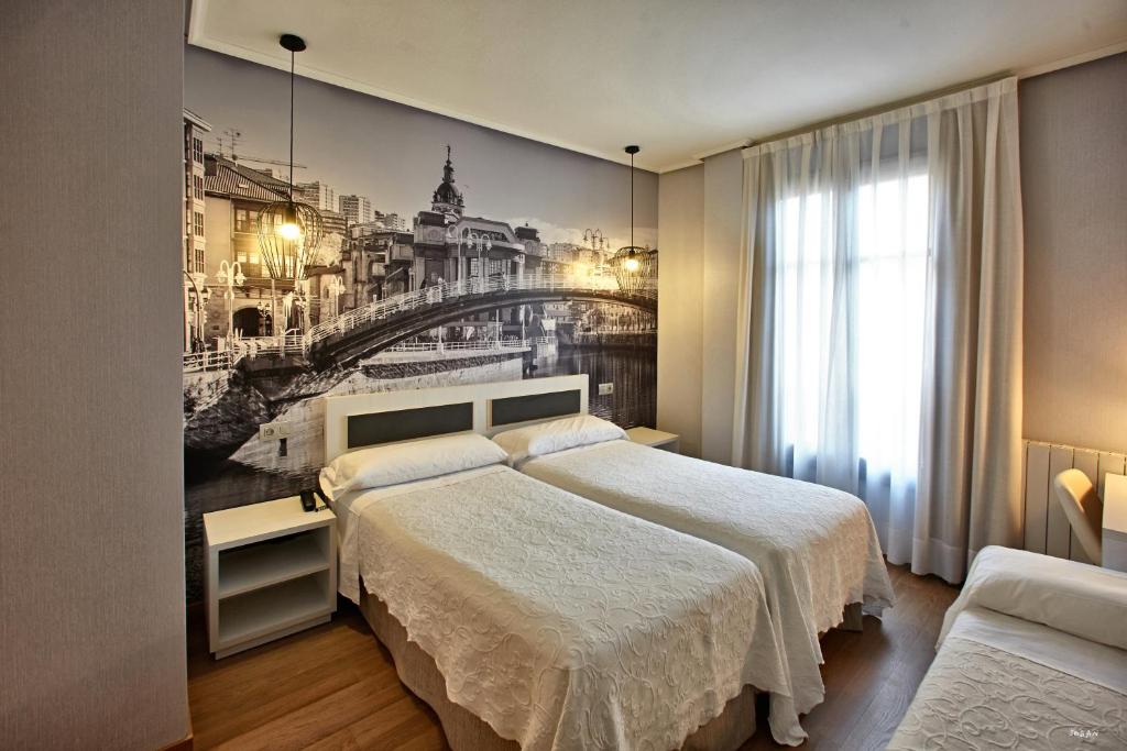 a bedroom with a bed and a painting of a bridge at Hotel Sirimiri in Bilbao