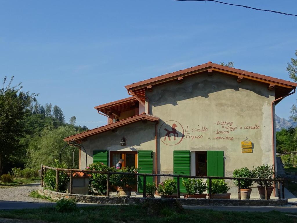 a small house with green shutters on the side at La Fattoria al Crocefisso in Pieve Fosciana