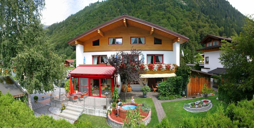 ein Haus mit Pool davor in der Unterkunft Pension Rudigier Appartements in Sankt Gallenkirch