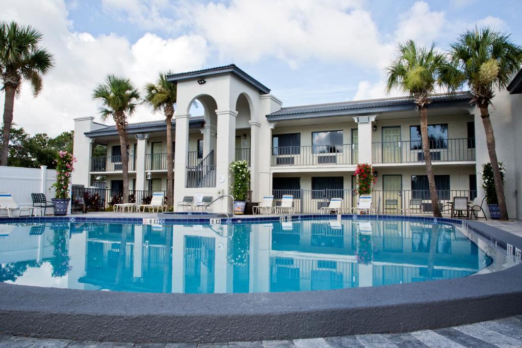 una piscina frente a un edificio con palmeras en The Ponce St. Augustine Hotel, en St. Augustine