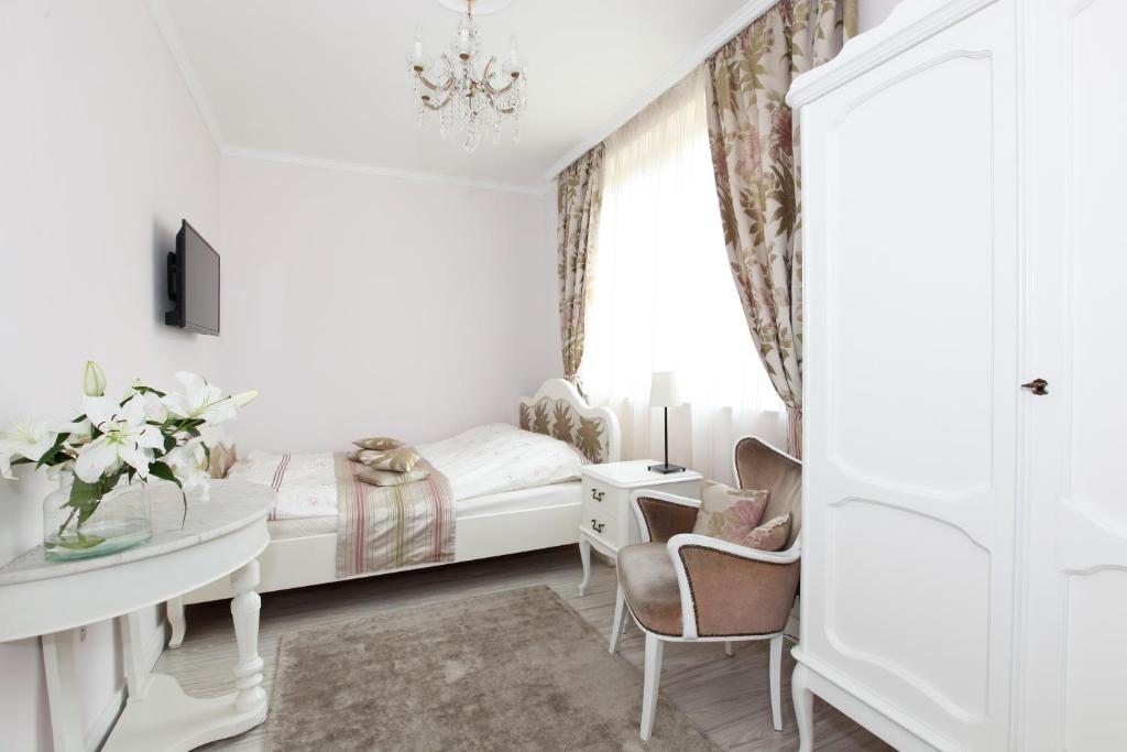 ソポトにあるSopot Romantic Apartmentの白いベッドルーム(ベッド1台、デスク、窓付)