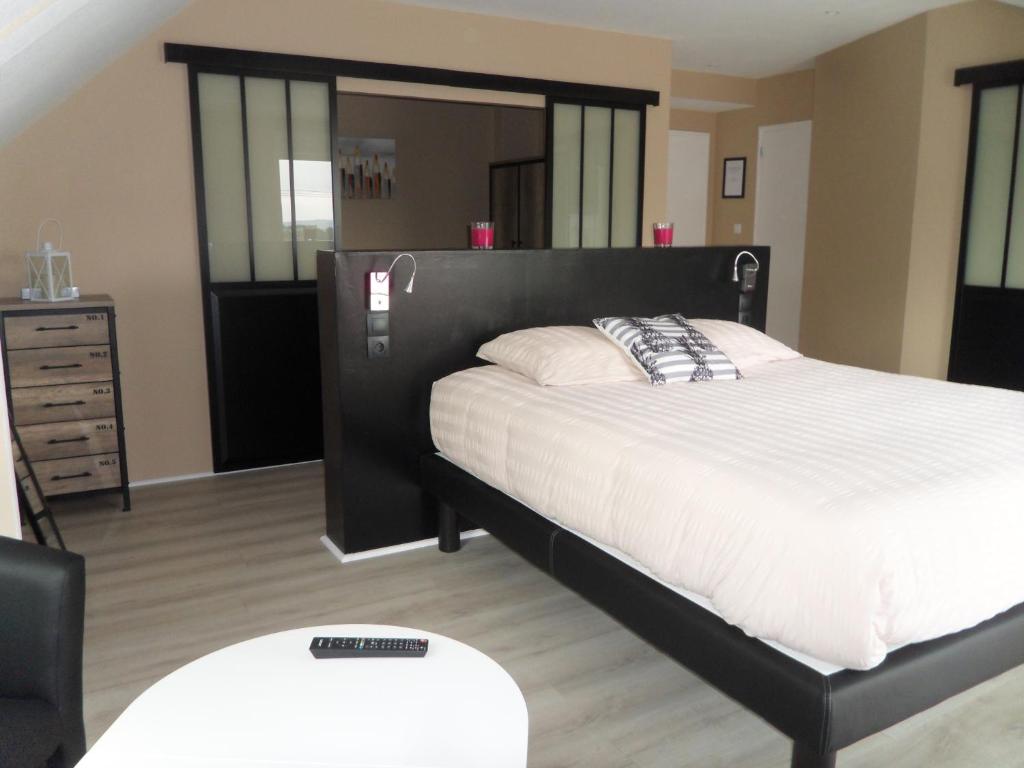 a bedroom with a large bed and a dresser at Manoir du Brugnobois in Surques