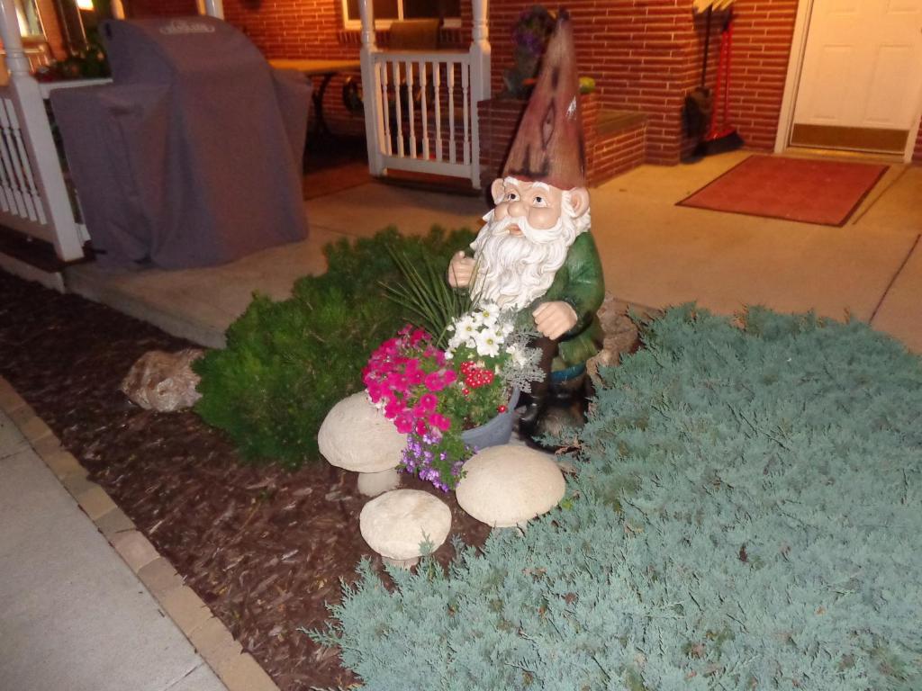 a garden with a bear and flowers in a yard at Husker Inn in North Platte