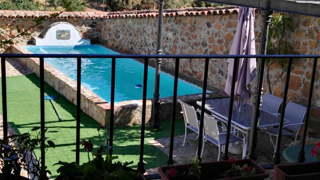 vistas a la piscina desde el balcón de una casa en Casa Rural EL Trillo, en El Alcornocal