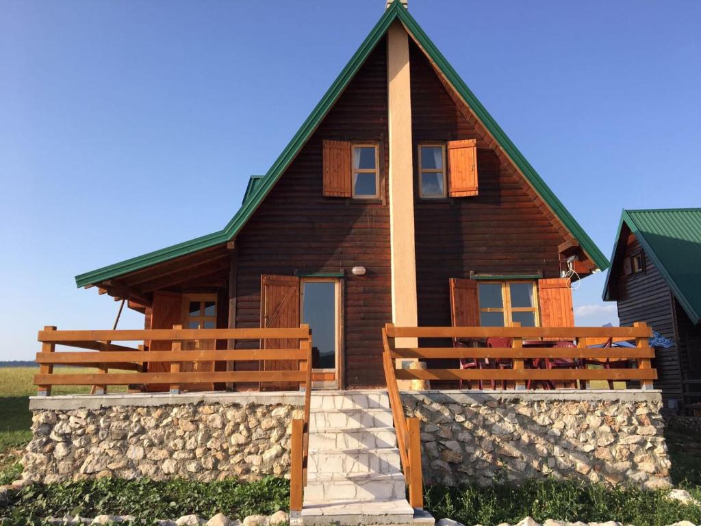 een groot houten huis met een groen dak bij Mountain view Lodges in Žabljak