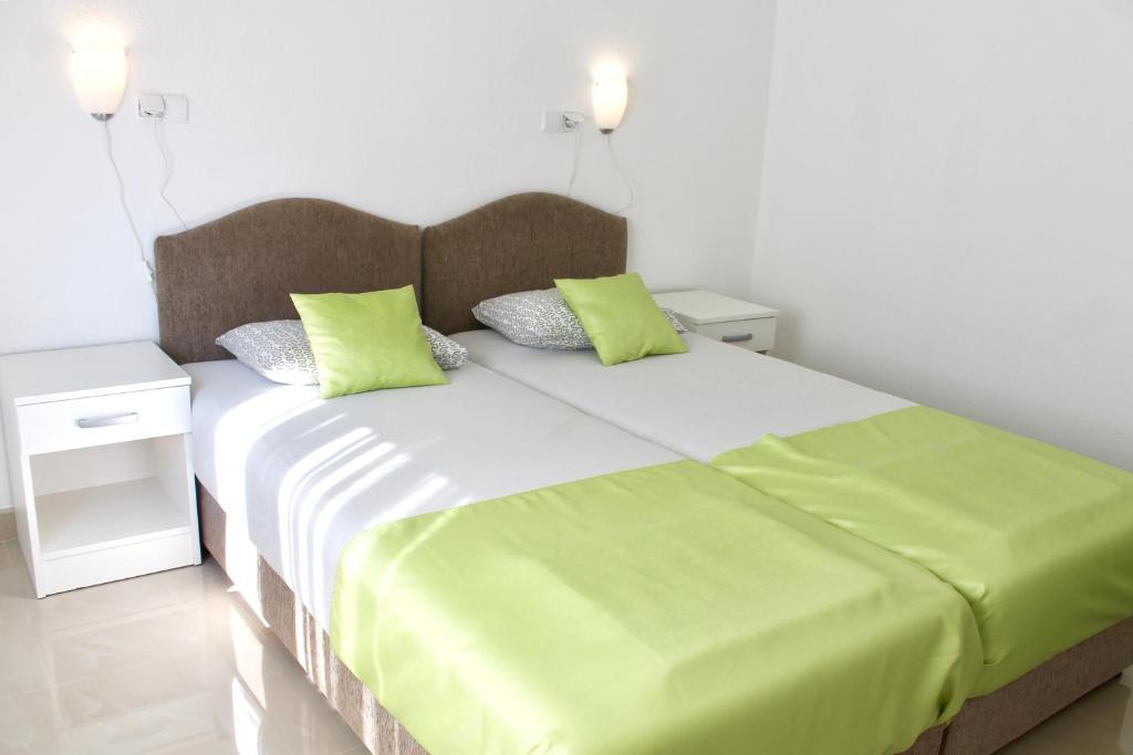 a bedroom with a large bed with green pillows at Apartments Villa Milna 1 in Budva