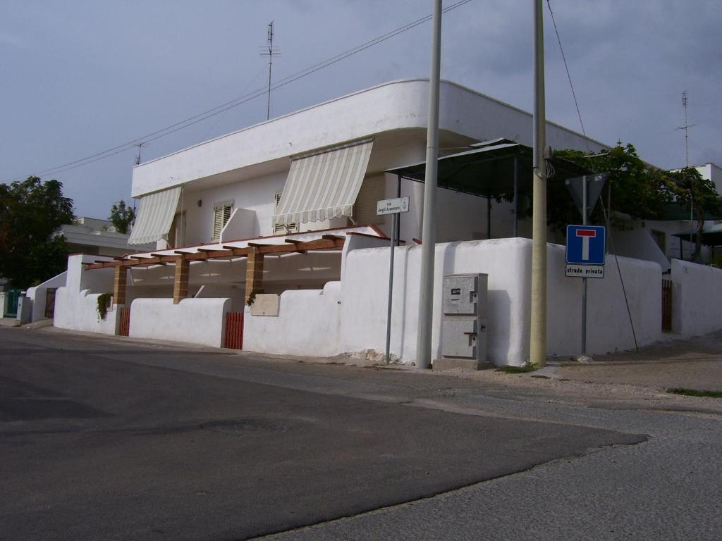 un edificio blanco al lado de una calle en casa posto cantoro 1, en Marina di Pescoluse