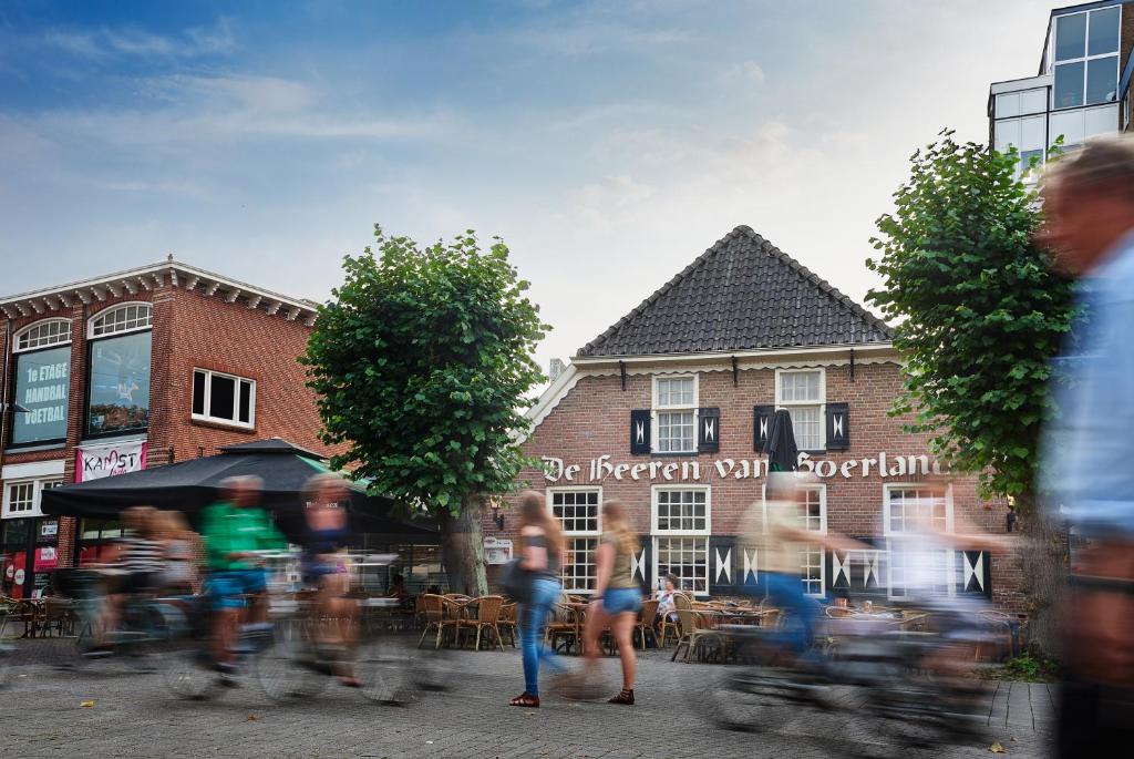 un grupo de personas montando bicicletas por una calle en Stads Hotel Boerland en Emmen